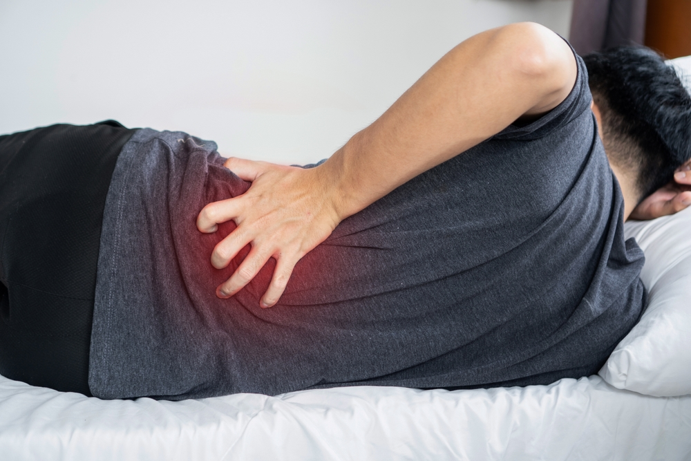 man holding his back due to pain from spinal stimulator problems - Lawsuit Legal News